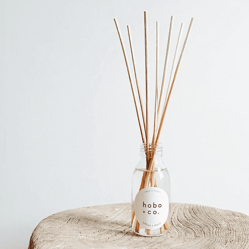 hobo-co-citrus-basil-reed-diffuser_optimized Hobo + Co. Citrus Basil Duftstäbchen in einer Glasflasche auf einem Holzuntergrund.