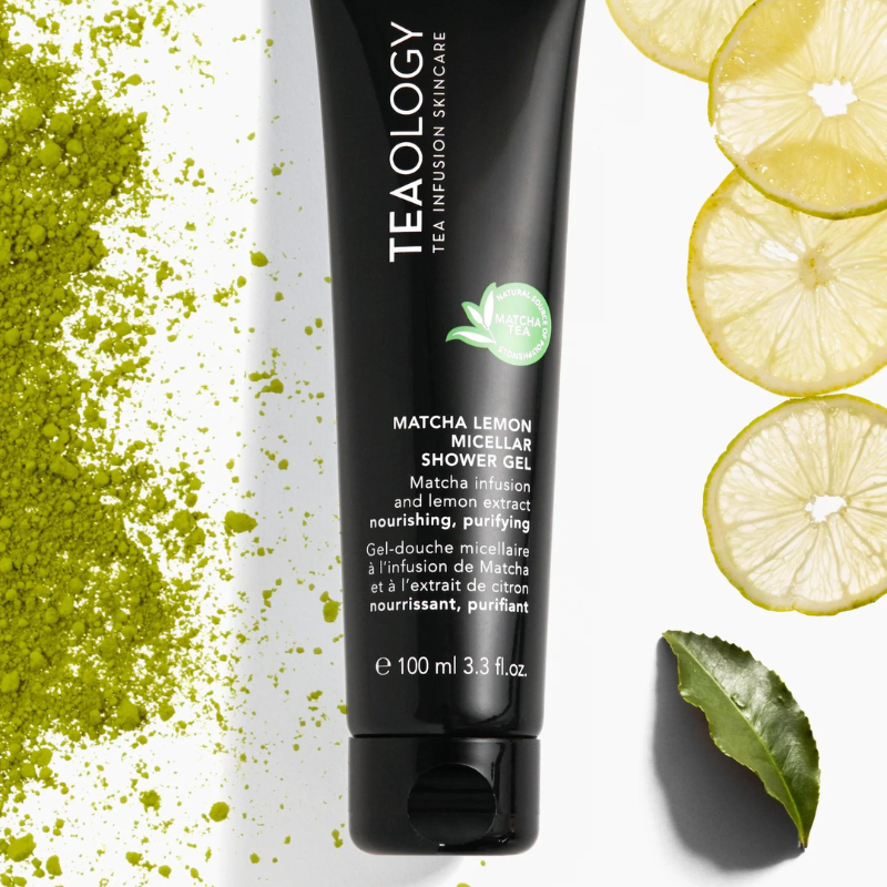 TEAOLOGY Matcha Lemon Micellar Shower Gel 100ml, schwarze Tube, umgeben von Matcha-Pulver, Zitronenscheiben und einem grünen Blatt.