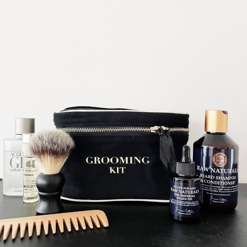 Grooming-Kit-Box Grooming-Kit mit Kamm, Rasierpinsel, Bartöl, Bartshampoo und Conditioner vor weißem Hintergrund.